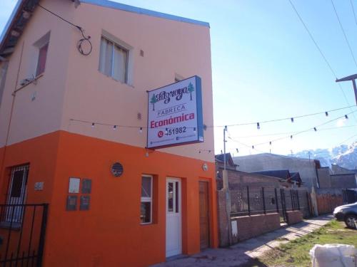 un edificio naranja y blanco con un cartel en él en Vicos en Esquel