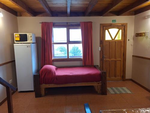 a small room with a window and a red bench at Departamentos Temporarios Cabañas Ushuaia in Ushuaia