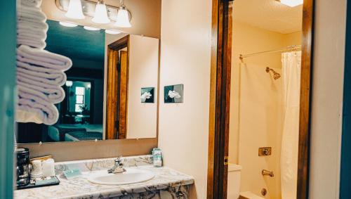 un bagno con lavandino e specchio di Wrangler Inn Mobridge a Mobridge