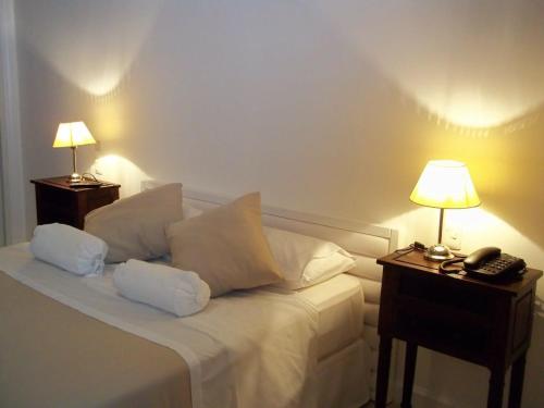 a bedroom with a bed with two lamps and a telephone at Green Park Punta del Este in Punta del Este