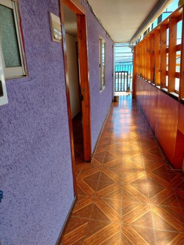a hallway with purple walls and a wooden floor at Noface in Los Vilos
