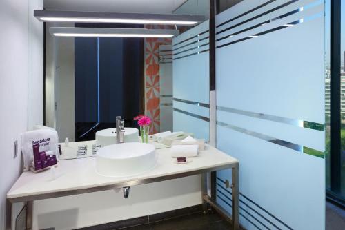 a bathroom with a sink and a mirror at Hotel Guadalajara Country Club by HNF in Guadalajara