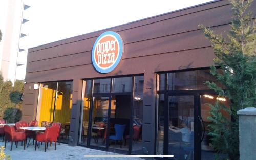 a fast food restaurant with red chairs and tables at Elegant Apartment in City Centre in Pristina