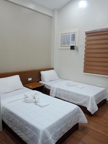 a room with two beds and a window at Villa Marilyn Resort and Hotel in Coron