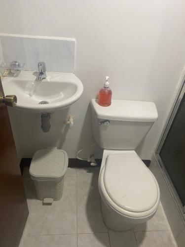 a bathroom with a toilet and a sink at Hospedaje Casa Dorada - Modelia in Bogotá