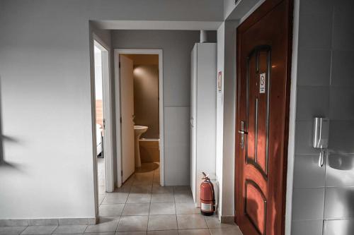 um corredor com um quarto com uma porta e um extintor de incêndio em Las Cumbres Ushuaia em Ushuaia