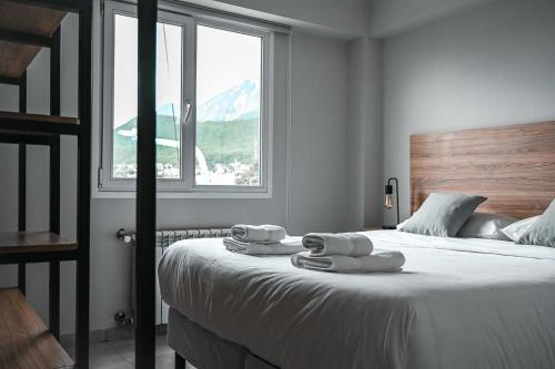 a bedroom with a large bed with towels on it at Las Cumbres Ushuaia in Ushuaia