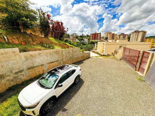 a white car parked on the side of a road at Pousada Ar da Montanha in Serra Negra