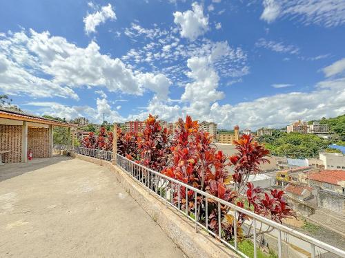 a fence with red plants on top of a building at Pousada Ar da Montanha in Serra Negra