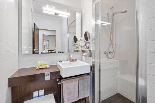 ein weißes Bad mit einem Waschbecken und einer Dusche in der Unterkunft Quality Inn Heritage on Lydiard in Ballarat
