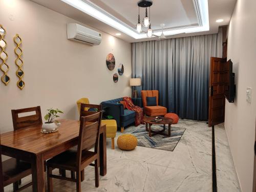 a living room with a dining table and chairs at Aura Home Stay in Mohali