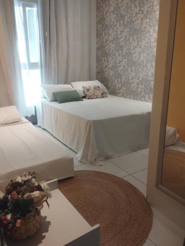 a bedroom with two beds and a basket of flowers at Muro Alto Condomínio Clube Térreo 106 in Porto De Galinhas