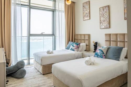 - une chambre avec 2 lits et une grande fenêtre dans l'établissement Veluxa - Luxe Beach Vista 2 Bed, à Dubaï