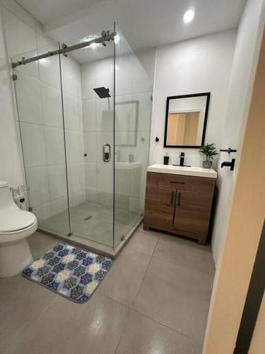 a bathroom with a shower and a toilet and a sink at Villa Casa Blanca. in Puerto Cortés