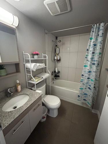a bathroom with a sink and a toilet and a tub at 1-bedroom condo near University of Waterloo in Waterloo