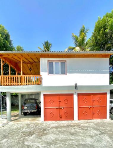 une maison avec des portes de garage rouges et un balcon dans l'établissement Fantástico espacio para alojarse, à Puerto Palenque