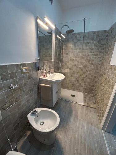 een badkamer met een wastafel, een toilet en een douche bij Il piacere appartaments in Caltagirone