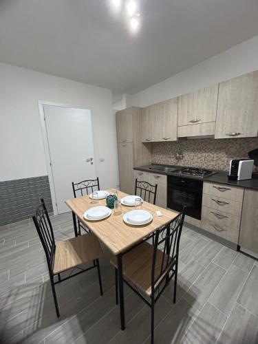 een keuken met een houten tafel en stoelen. bij Il piacere appartaments in Caltagirone