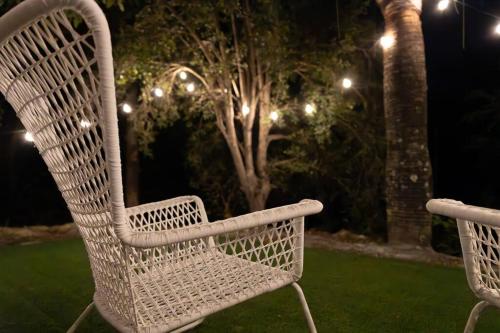 two white chairs sitting in the grass at night at Peaceful Studio Close to shops, motorway, national forest & koalas! in Tanah Merah