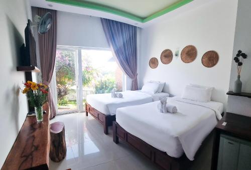 a hotel room with two beds and a window at Tuong Vy Boutique Hotel Mui Ne in Mui Ne