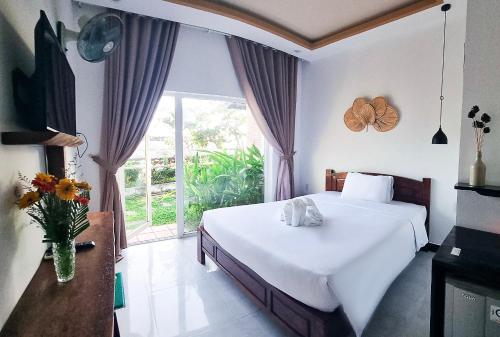 - une chambre avec un lit et une grande fenêtre dans l'établissement Tuong Vy Boutique Hotel Mui Ne, à Mui Ne
