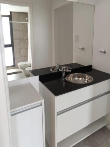a white bathroom with a sink and a toilet at Accarezza in Villa Carlos Paz