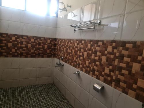 W łazience z oknem znajduje się prysznic wyłożony kafelkami. w obiekcie River Rock Homestay w mieście Anachal