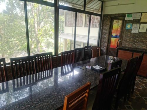 a dining room with a long table and chairs at River Rock Homestay in Anachal