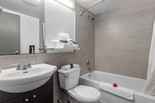 a bathroom with a sink and a toilet and a tub at Restauparc Motel in Casselman