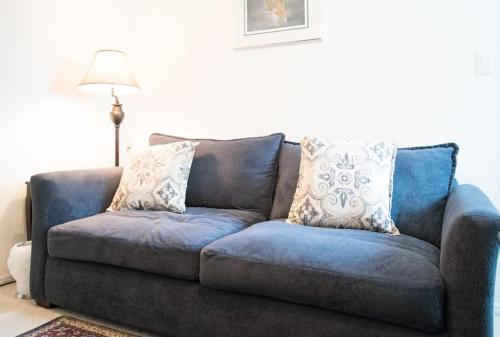 a blue couch with pillows in a living room at 2 room luxury suite near airport & The Woodlands in Houston
