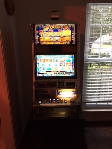 a video game machine in front of a window at 2 room luxury suite near airport & The Woodlands in Houston