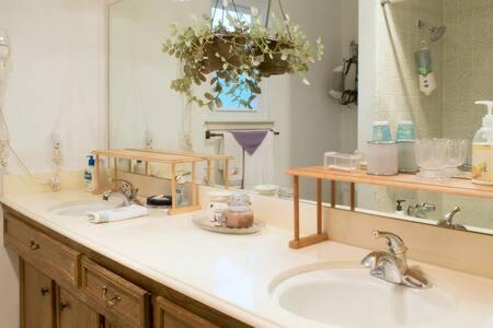 a bathroom with two sinks and a large mirror at 2 room luxury suite near airport & The Woodlands in Houston