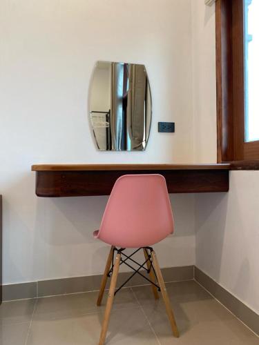 a pink chair sitting in front of a mirror at B2 Hotel Savannakhet in Savannakhet