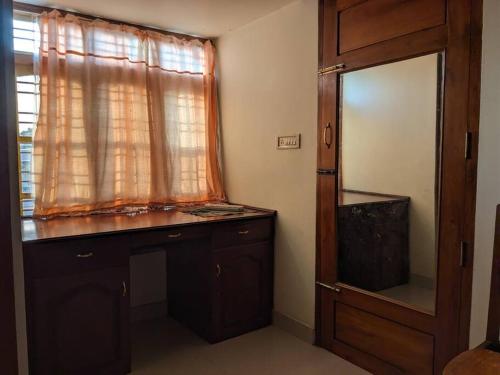 a bathroom with a mirror and a dresser and a window at Modern City Oasis in Kollam