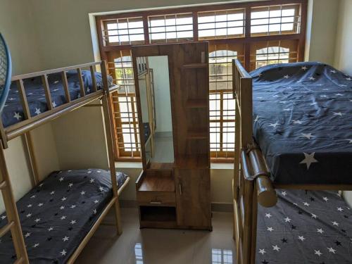a room with two bunk beds and a staircase at Modern City Oasis in Kollam