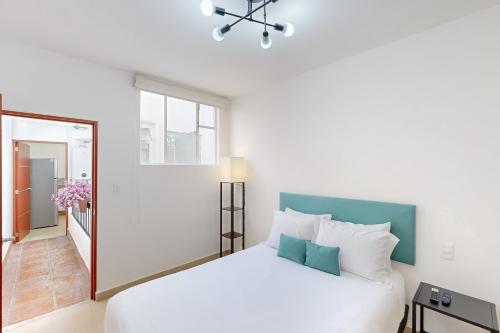 biała sypialnia z łóżkiem i oknem w obiekcie Blooming Hideaway @ Cadetes 303 w mieście Meksyk