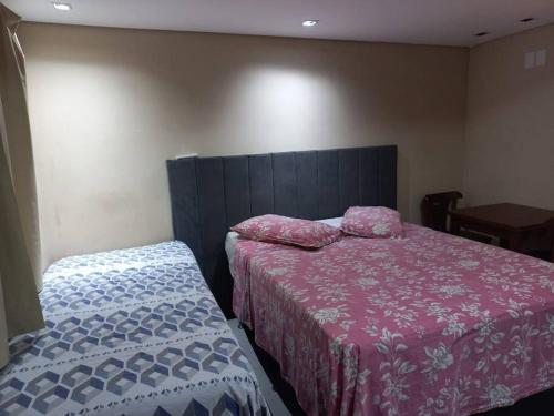 Suíte no centro de Paraty في باراتي: غرفة نوم بسريرين وطاولة وسرير