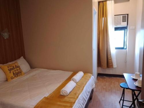 um pequeno quarto com uma cama com toalhas em SEAVIEW INN em Catbalogan