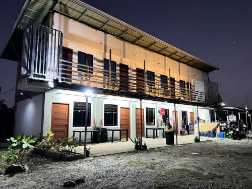 a building with a balcony on top of it at night at Villa Mariano Travellers Pad in Laoag