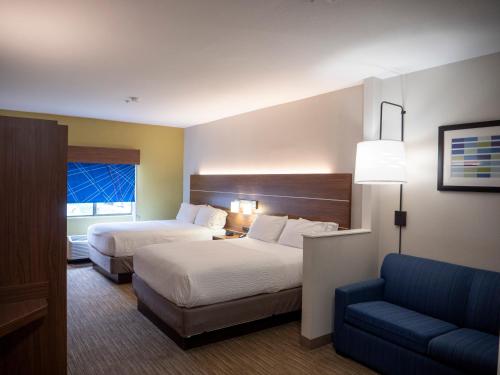 um quarto de hotel com duas camas e um sofá em Holiday Inn Express & Suites I-85 Greenville Airport, an IHG Hotel em Greenville