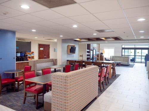 a dining room with tables and red chairs at Holiday Inn Express & Suites Greenville Airport i85 by IHG in Greer
