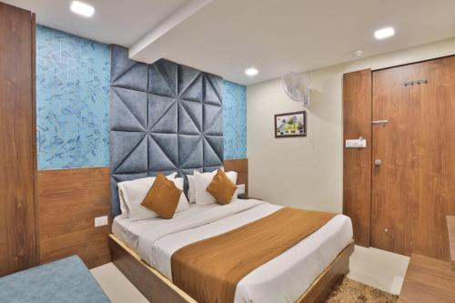 ガンディーナガルにあるHOTEL REST INNのベッドルーム1室(大型ベッド1台、木製のドア付)