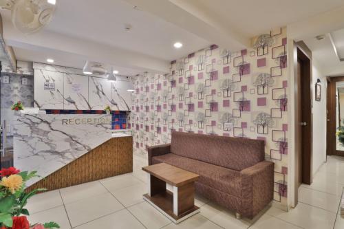 a lobby with a couch and a map on the wall at HOTEL REST INN in Gandhinagar