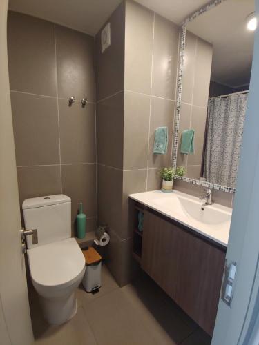 un baño con inodoro y lavabo en Departamento Laguna del Mar, en La Serena