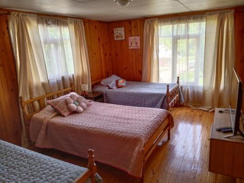 a bedroom with two beds and a tv and windows at Hospedaje Martita. in Putemún