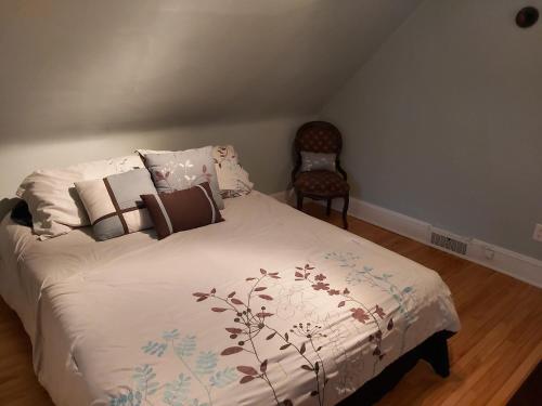 - une chambre avec un lit doté d'oreillers et d'une chaise dans l'établissement 2 bedroom apartment in historical home, à Barrie