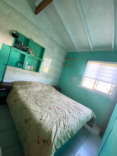 um pequeno quarto com uma cama e uma janela em Cabaña a metros de playa em Valdivia