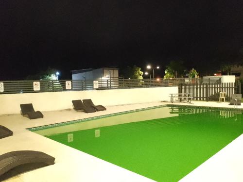 uma piscina com água verde à noite em Tu torre monumental Vl em Santiago de los Caballeros