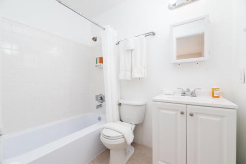een witte badkamer met een toilet en een wastafel bij The Retreat 1 - Wilton Manors in Fort Lauderdale