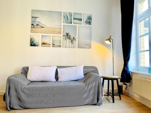 un divano in soggiorno con tre dipinti sul muro di Modernes Altstadtappartment Schulstraße - ABC356 a Wismar